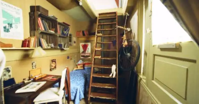 Interior de casa histórica de color amarillo con escritorio, libros y fotos en paredes