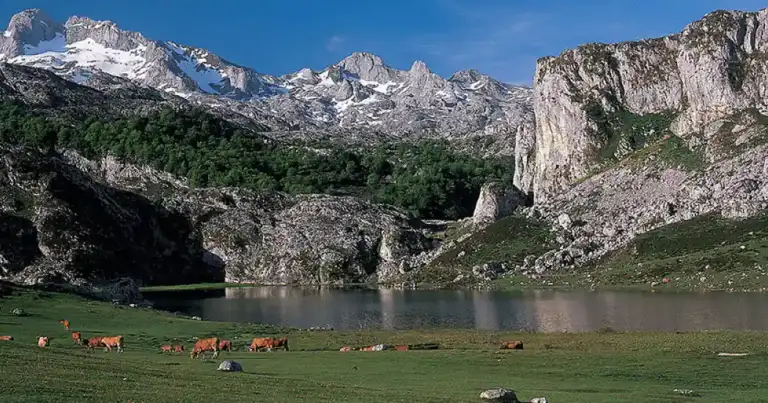 Lagos en valle montañoso con iglesia y prados verdes