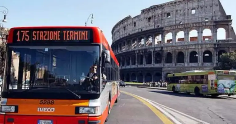 un bus rojo pasa al costado del coliseo
