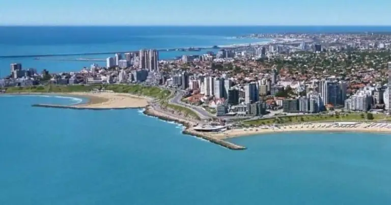 Vista aérea de ciudad costera con playa de aguas turquesas