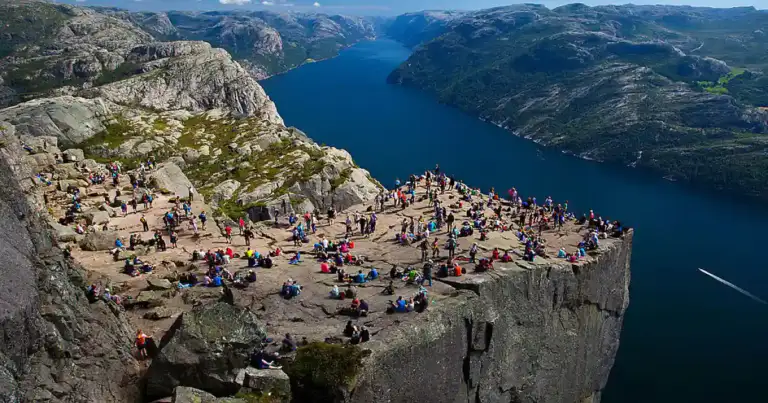 pulpito de roca,con mucha gente sentada encima de la roca disfrutando el paisaje.