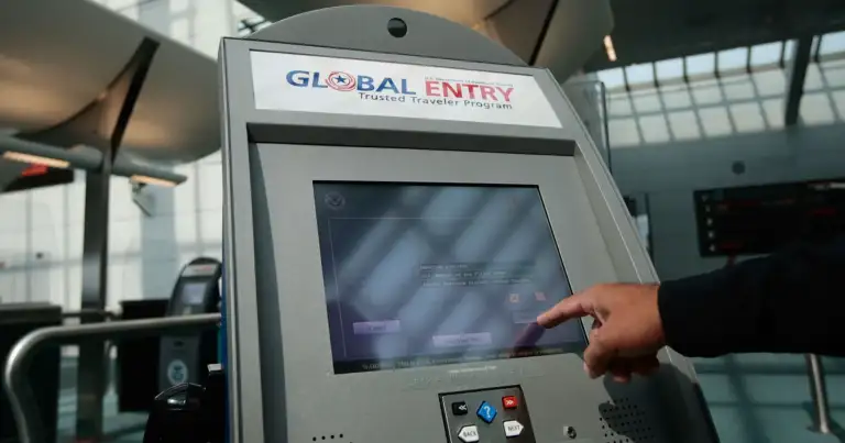 Mano en pantalla de máquina biométrica de control de migraciones