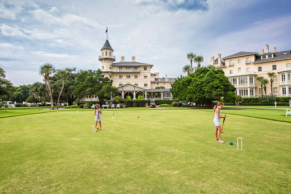 Dos personas jugando croquet en campo de hierba verde del resort histórico