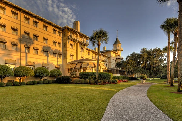 Edificio histórico de ladrillo rojo con jardines verdes y acceso a playa en Jekyll Island