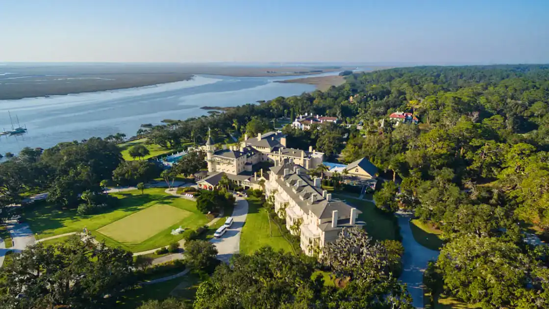 Mansión histórica grande rodeada de jardines y laguna junto a bosque