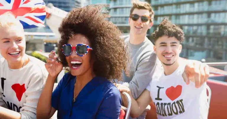 Grupo de personas sonriendo en azotea con ciudad de fondo