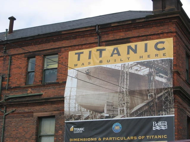 Fachada de ladrillo rojo con cartel Titanic Belfast y foto del barco