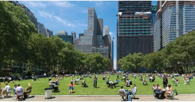 Parque verde urbano entre rascacielos de Nueva York con visitantes sentados