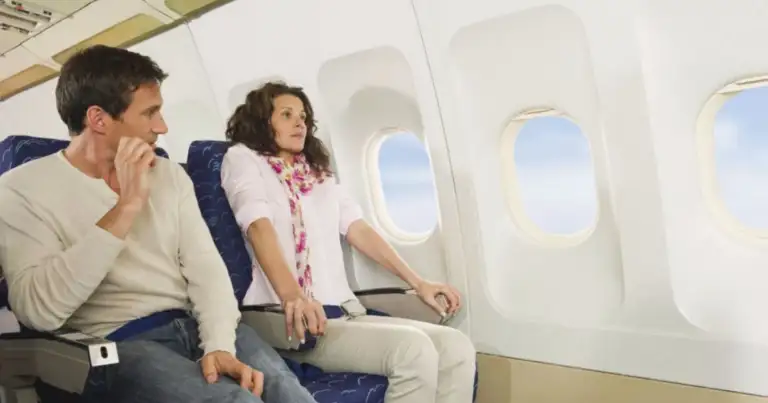 Dos pasajeros en asientos de avión junto a ventanillas