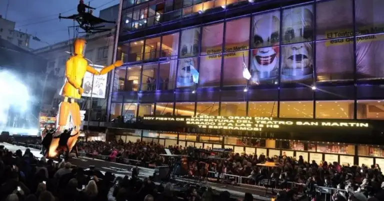 Estatua dorada de persona en escenario teatral con multitud de espectadores