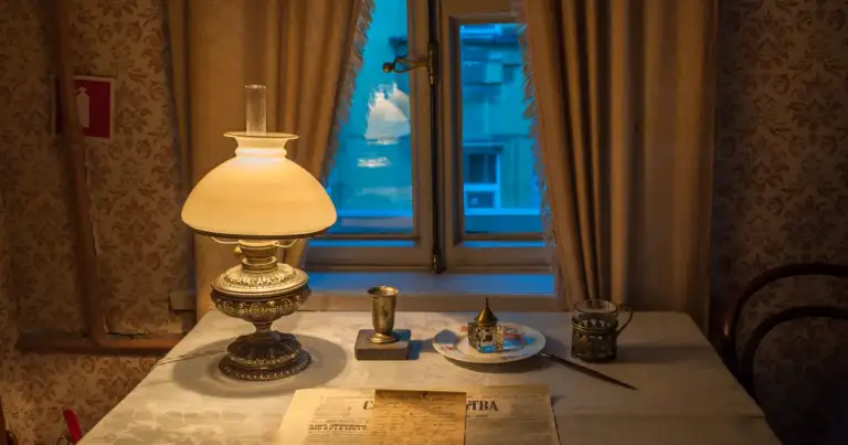Escritorio histórico con lámpara de aceite, documentos antiguos y vistas nocturnas
