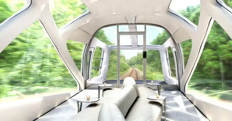 Interior de tren de lujo con asientos de cuero, ventanas panorámicas y paisaje verde exterior
