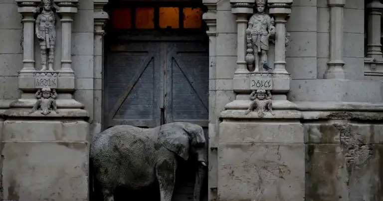Puerta ornamental de piedra gris con escultura de elefante