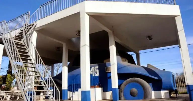 Edificio blanco y azul con auto de carrera azul