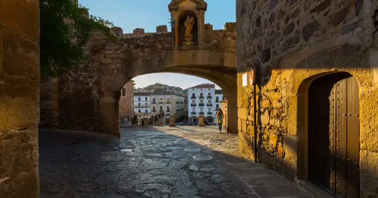 Arco medieval de piedra con plaza detrás