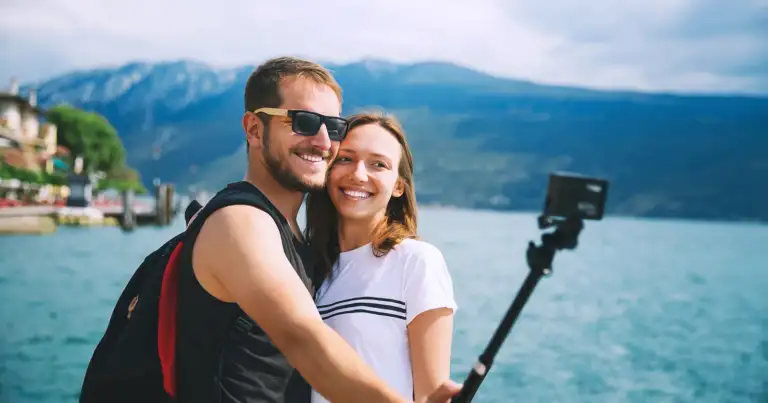 Una pareja disfrura sacandose fotos en la playa