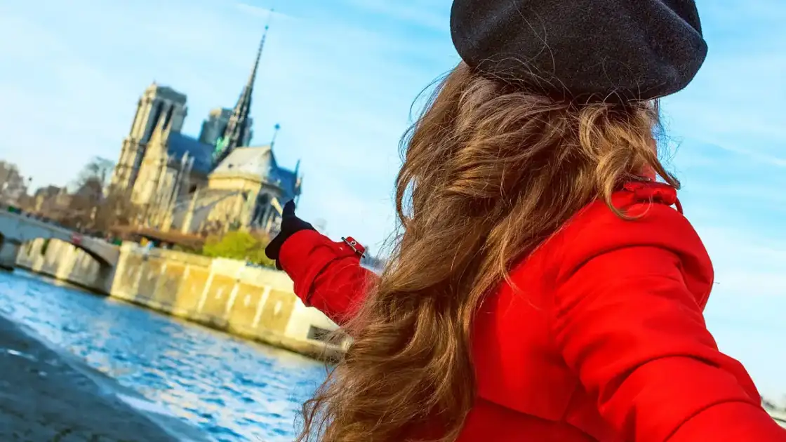 qué ver en paris: una mujer vestida de rojo con boina señala la ile de la cite