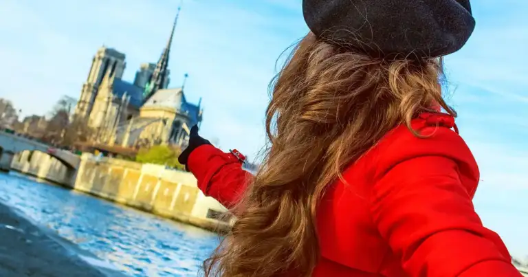 qué ver en paris: una mujer vestida de rojo con boina señala la ile de la cite