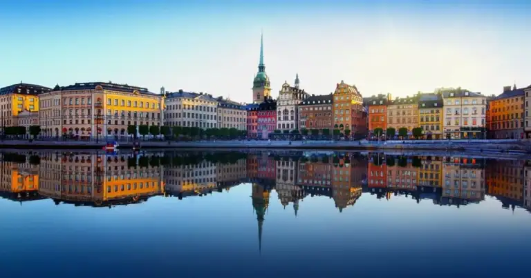 Edificios colorados junto a río con reflejo perfecto