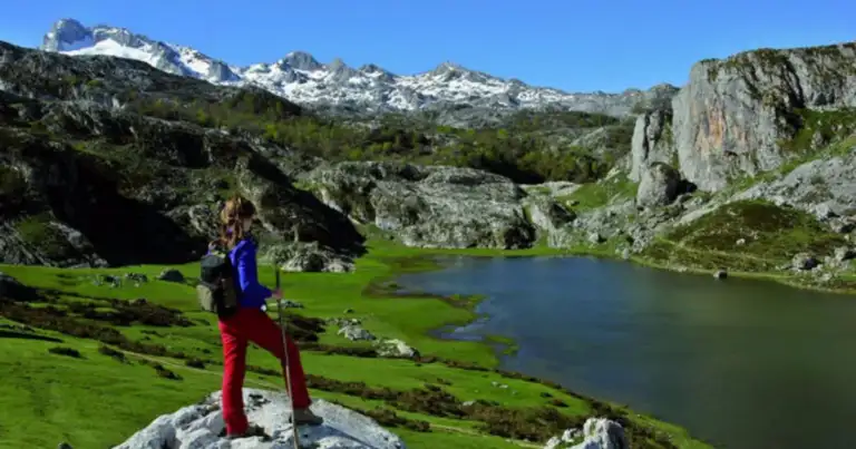 picos de europa, un lago y un turista mirando desde una piedra