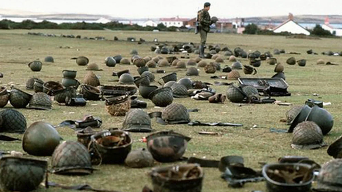 Soldado de pie entre cascos militares en campo