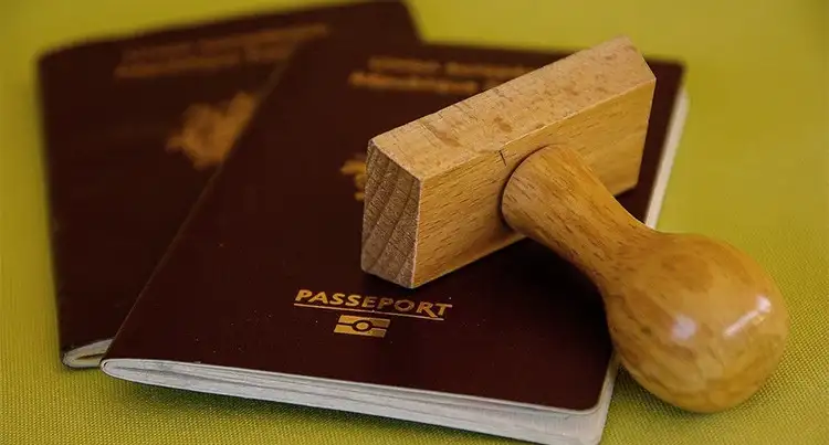 Pasaporte con sello de madera sobre superficie amarilla