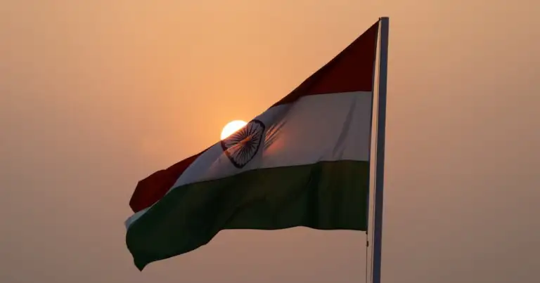 Bandera de India ondeando al atardecer con el sol de fondo