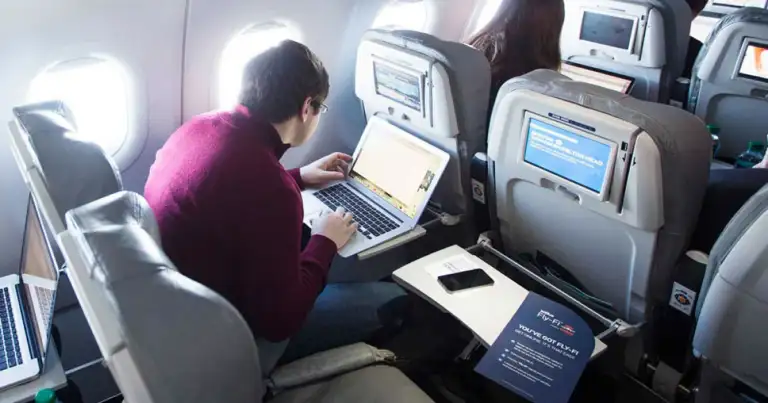 Personas en avión trabajando con laptops en vuelo