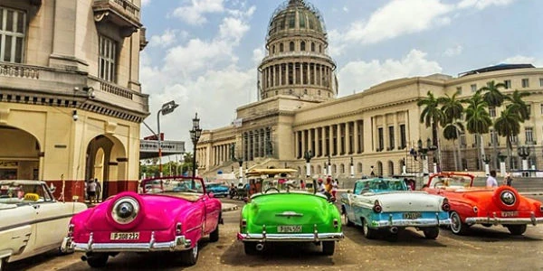 Capitolio cubano con autos vintage de colores frente a plaza