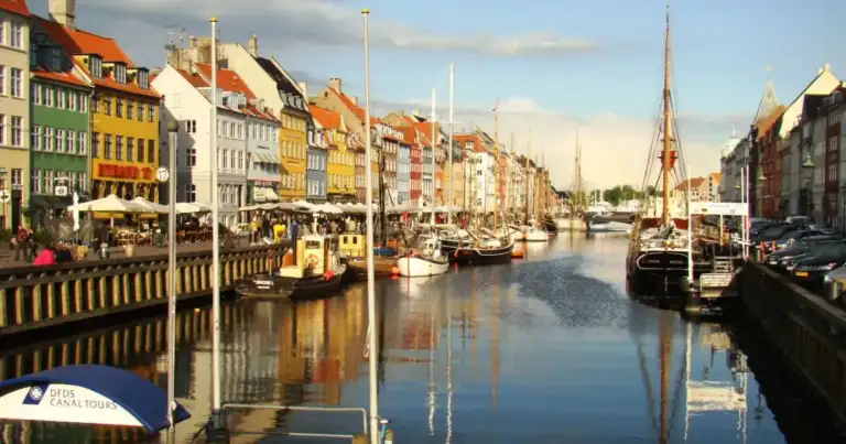 Canal de Copenhague con barcos, edificios coloridos y arquitectura tradicional