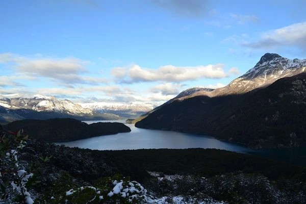 Lago azul rodeado de montañas nevadas y bosque en el Parque Los Alerces