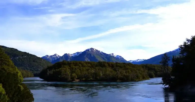 Montañas nevadas junto a río en bosque