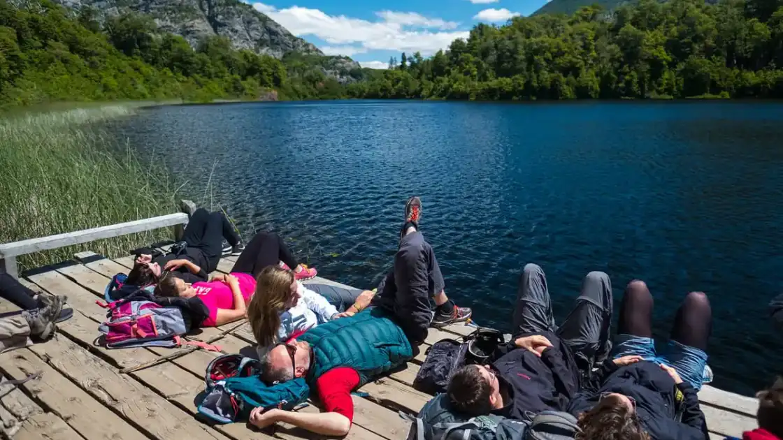 Personas descansando sobre un muelle junto a un lago en la Patagonia argentina