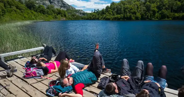 Personas descansando sobre un muelle junto a un lago en la Patagonia argentina