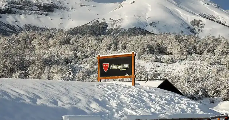 Montaña nevada con logo de centro de esquí