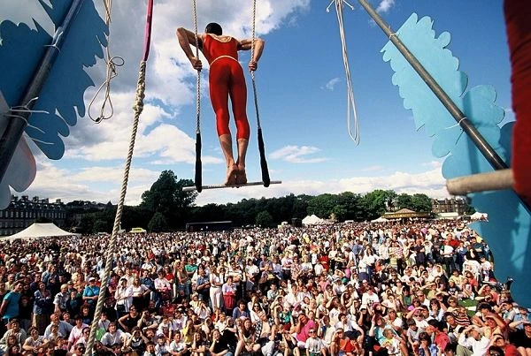 Acróbata colgado en el aire durante el Festival de Edimburgo ante multitud de espectadores