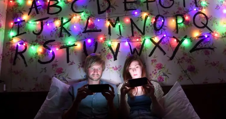 una pareja recostada viendo netflix con luces de colores