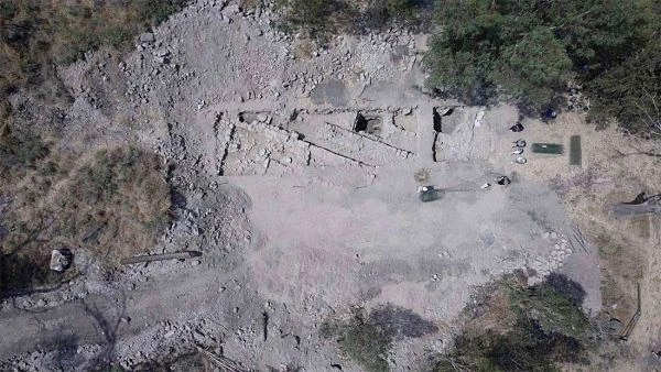 Aerial view of ancient site with ruins and structures scattered among vegetation