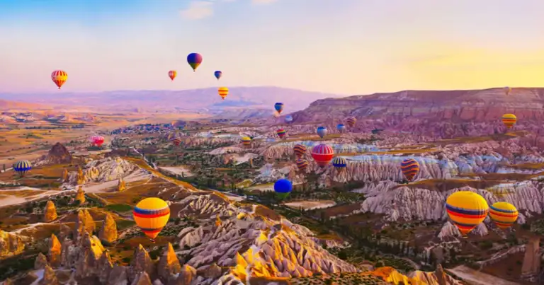 Globos aerostáticos sobre el paisaje rocoso de Capadocia al amanecer