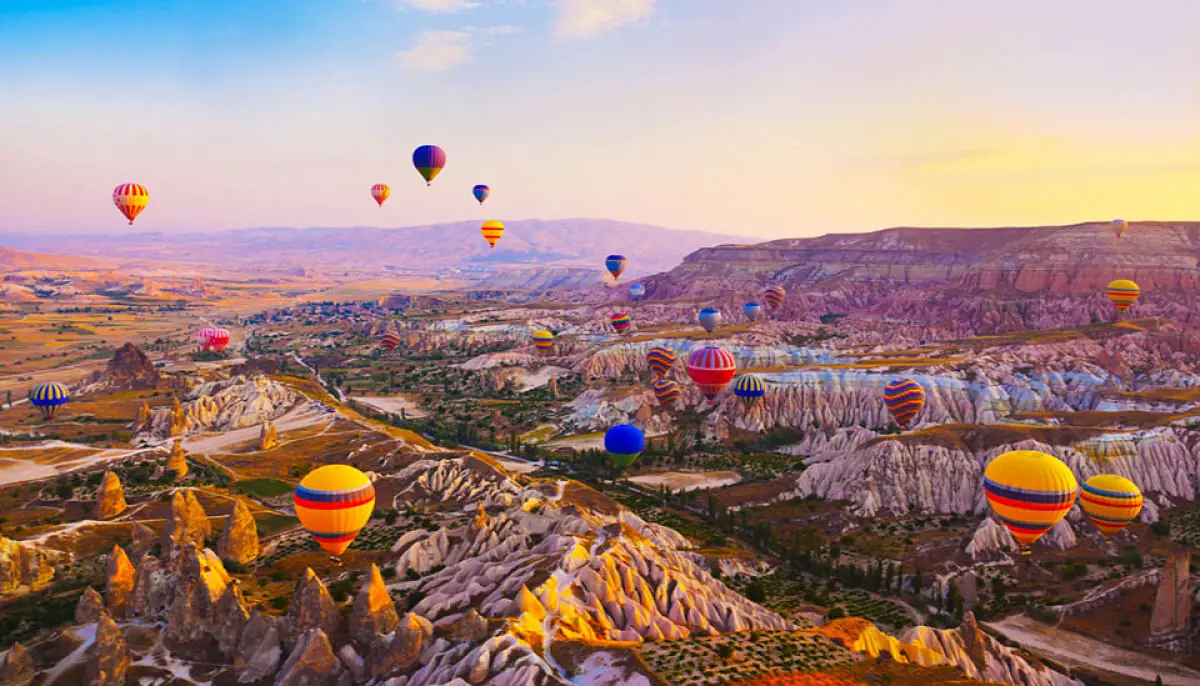 Globos aerostáticos sobre el paisaje rocoso de Capadocia al amanecer