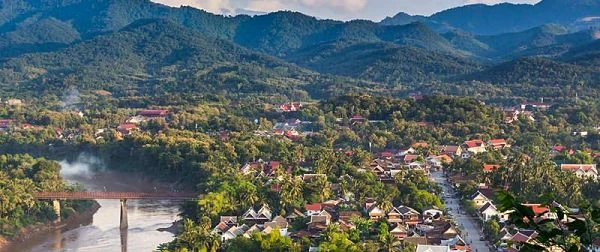 Pueblo en valle entre montañas con río y vegetación verde