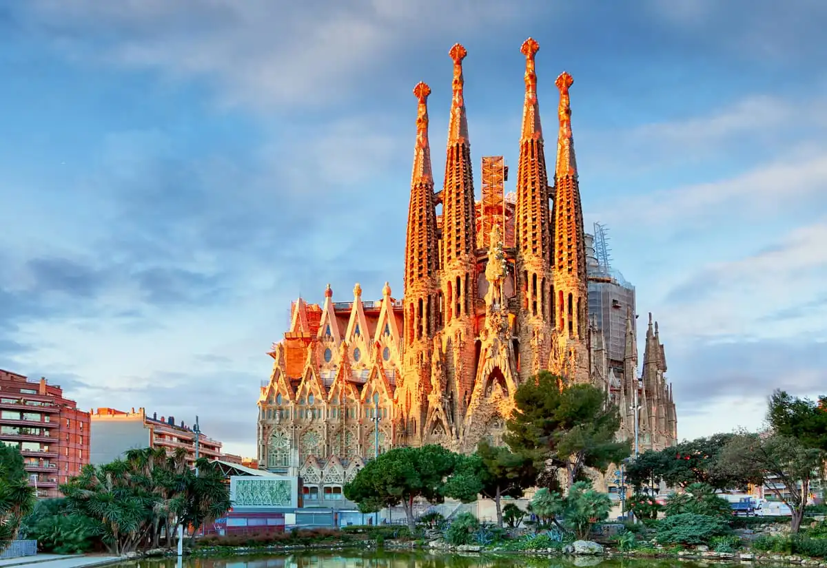 Basílica con torres rojas y blancas bajo cielo parcialmente nublado