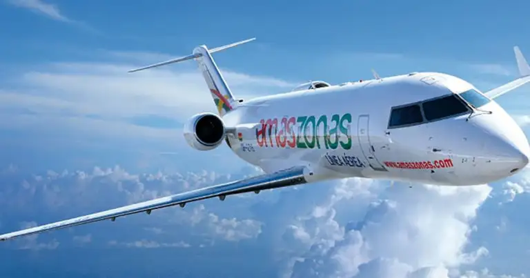 Avión Amazonas volando entre nubes sobre cielo azul