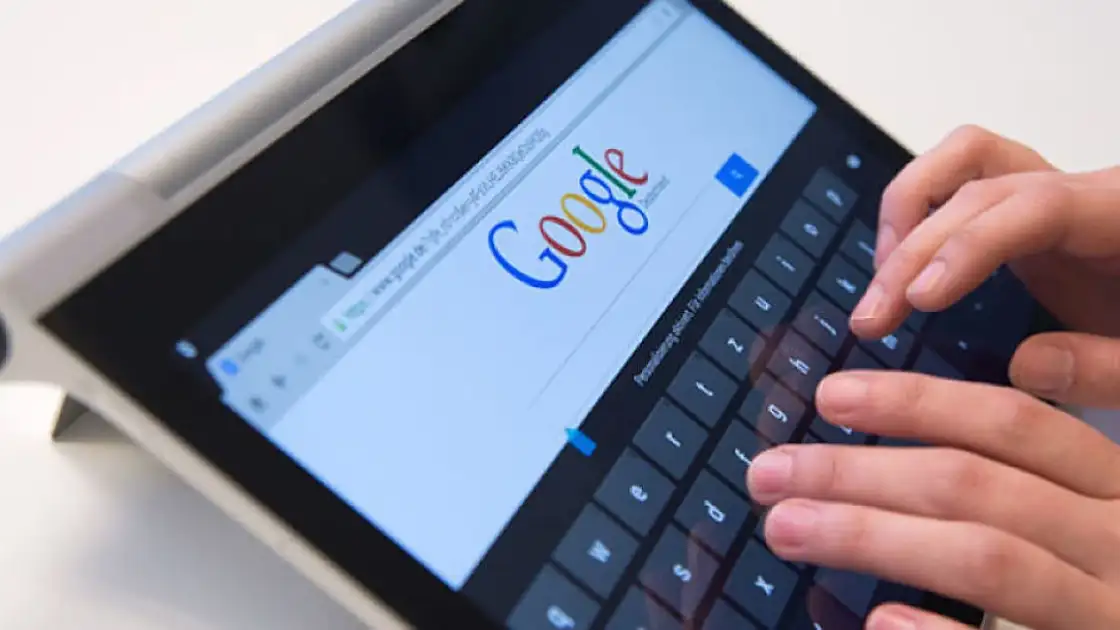 Mano escribiendo búsqueda en Google en una tablet