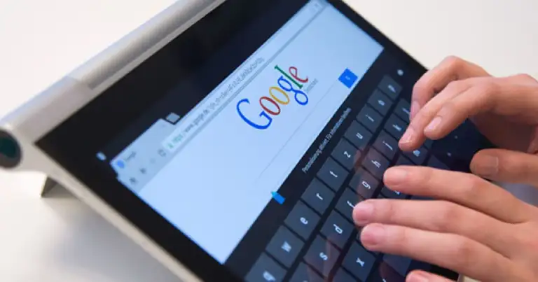 Mano escribiendo búsqueda en Google en una tablet