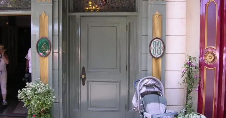 Entrada elegante con columnas doradas y plantas blancas