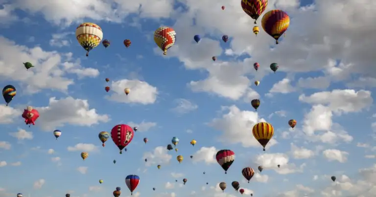 Decenas de globos aerostáticos de colores flotando en el cielo
