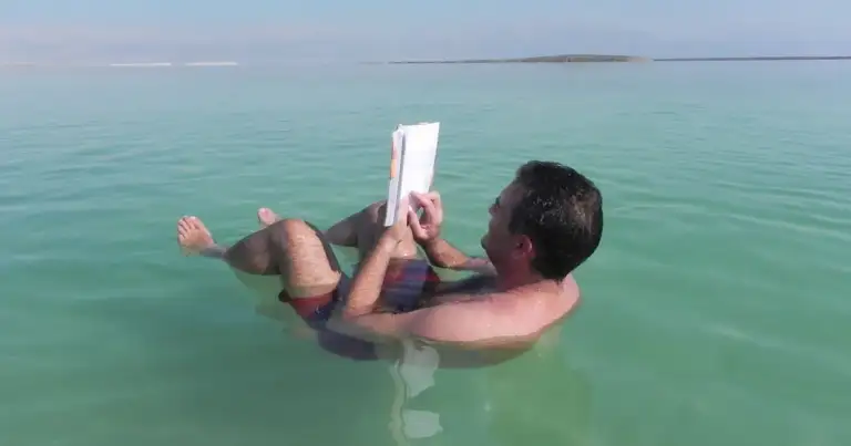 hombre flotando en el mar muerto leyendo un libro