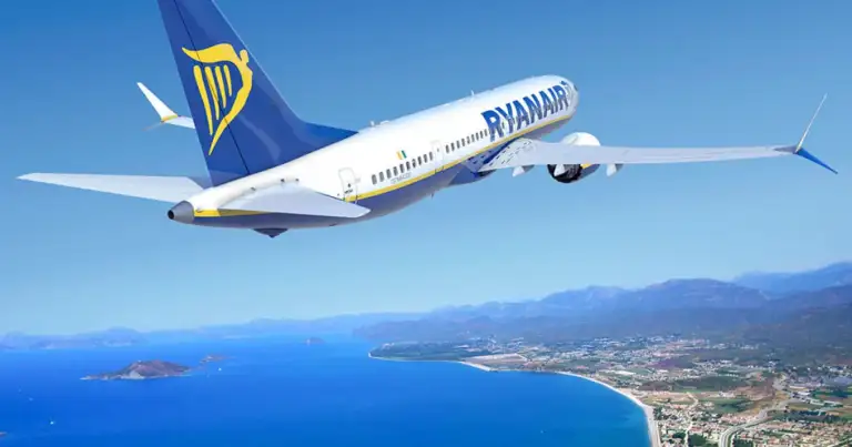 Avión Ryanair despegando sobre la costa con aguas turquesas