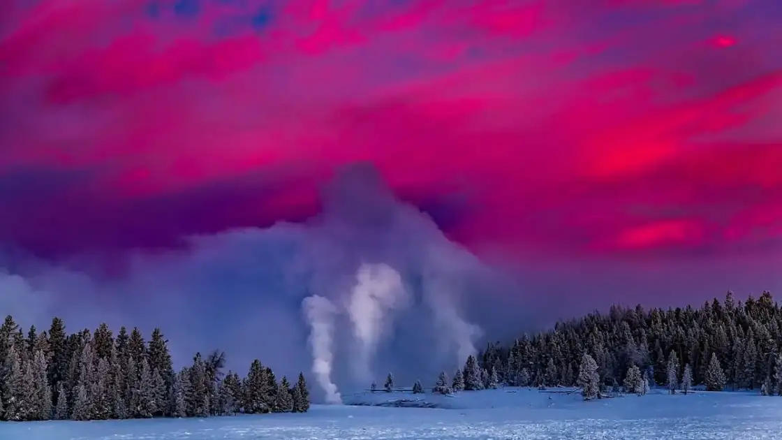 Geiser humeante en paisaje nevado con cielo púrpura